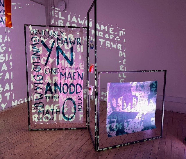 Overlapping text banners hanging from metal frames with text projection