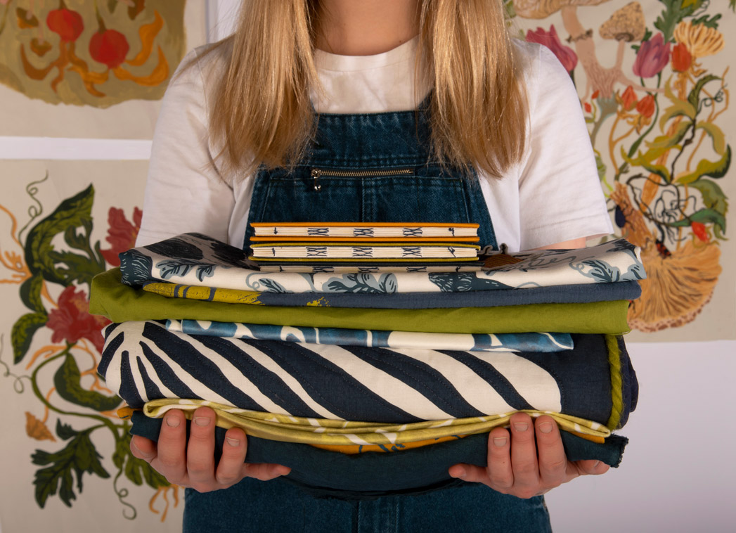 Woman holding a pile of textiles samples