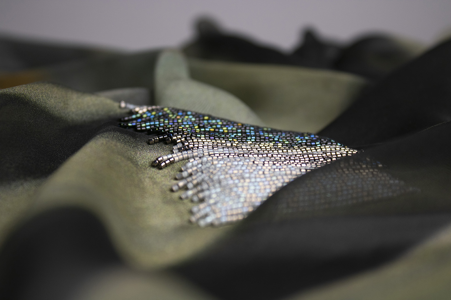 a close up of some silver,  iridescent blue and grey beading