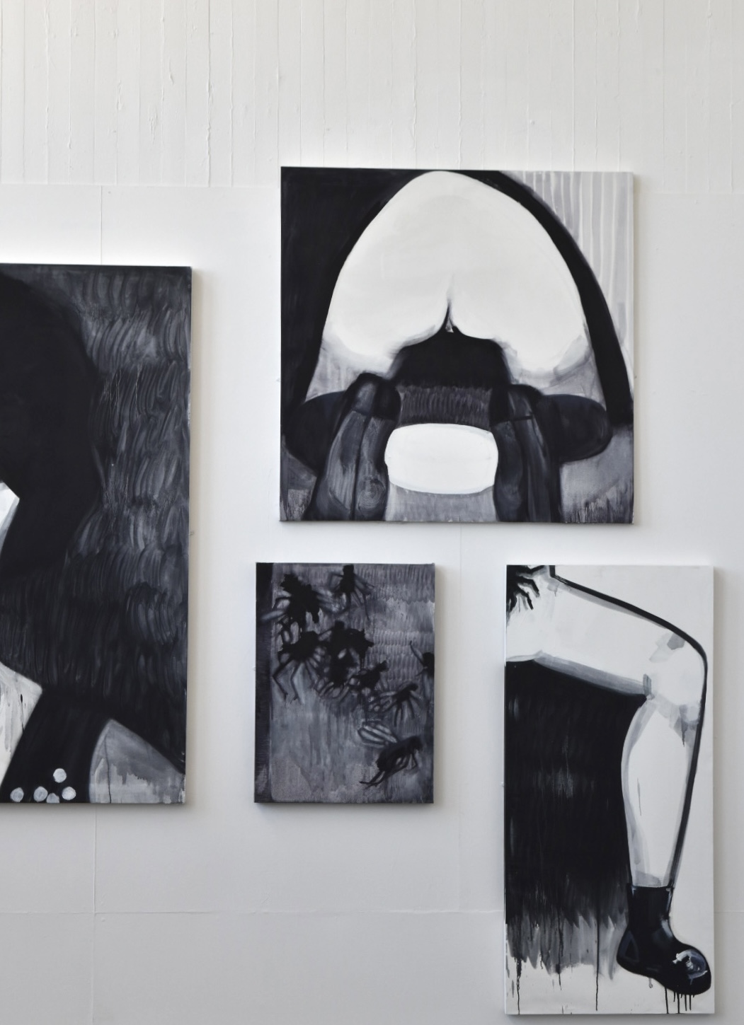 collection of black and white canvases on the wall, a bum, a leg, a side of a womans head and dead flies 