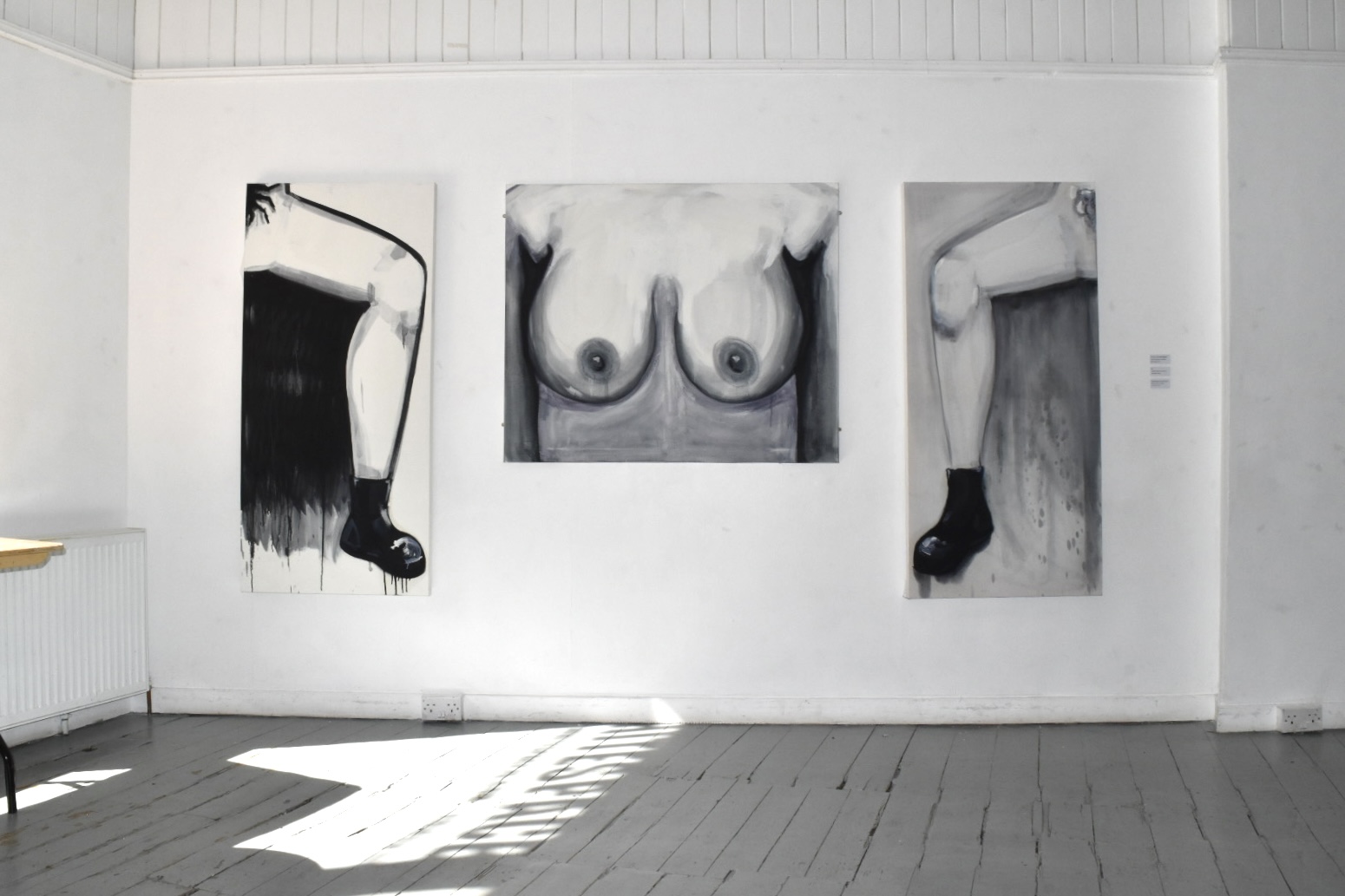 2 paintings with a painting of breasts in the middle of them, black and white paintings 