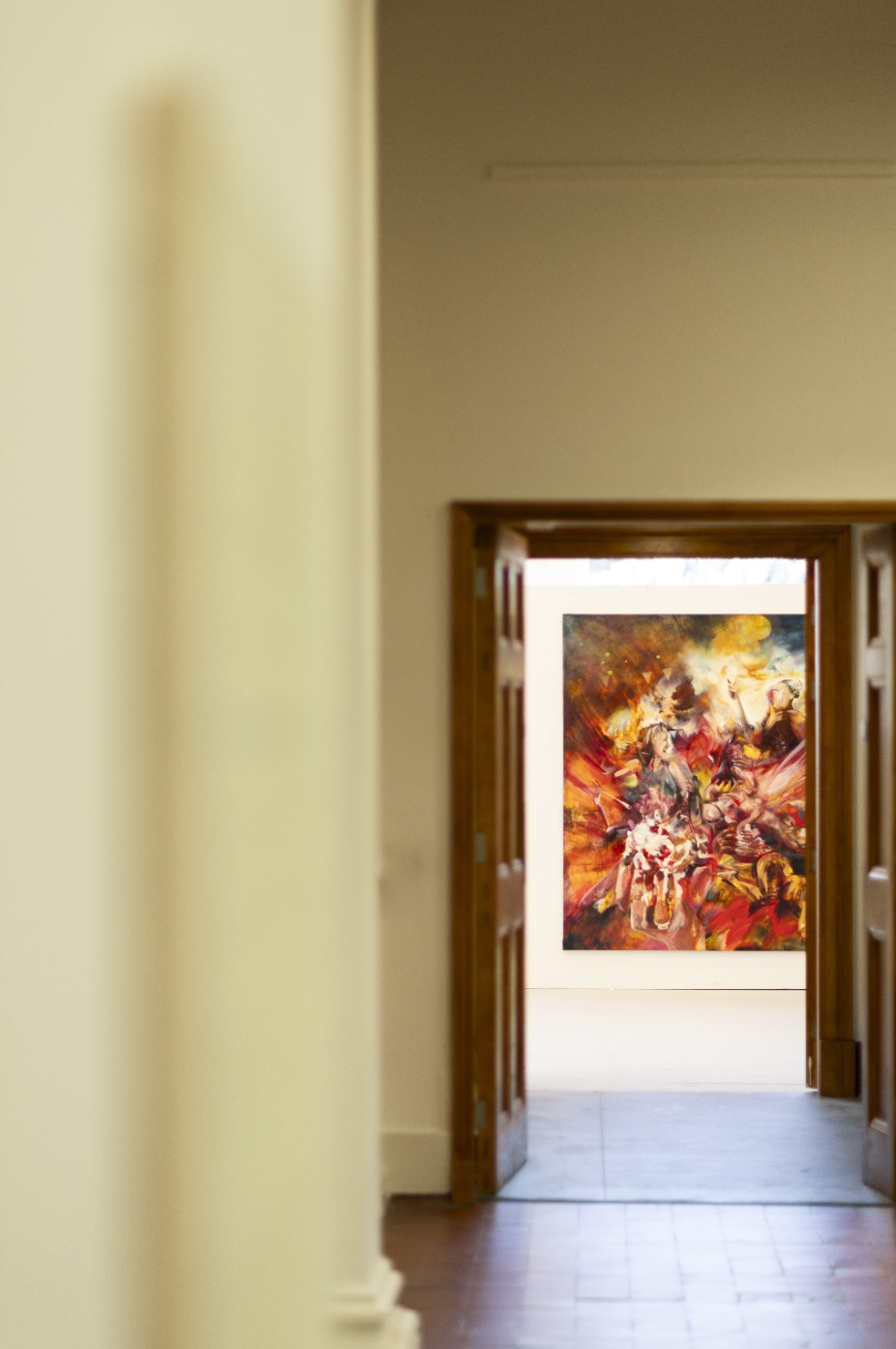 Photo through a corridor into the room looking on the painting