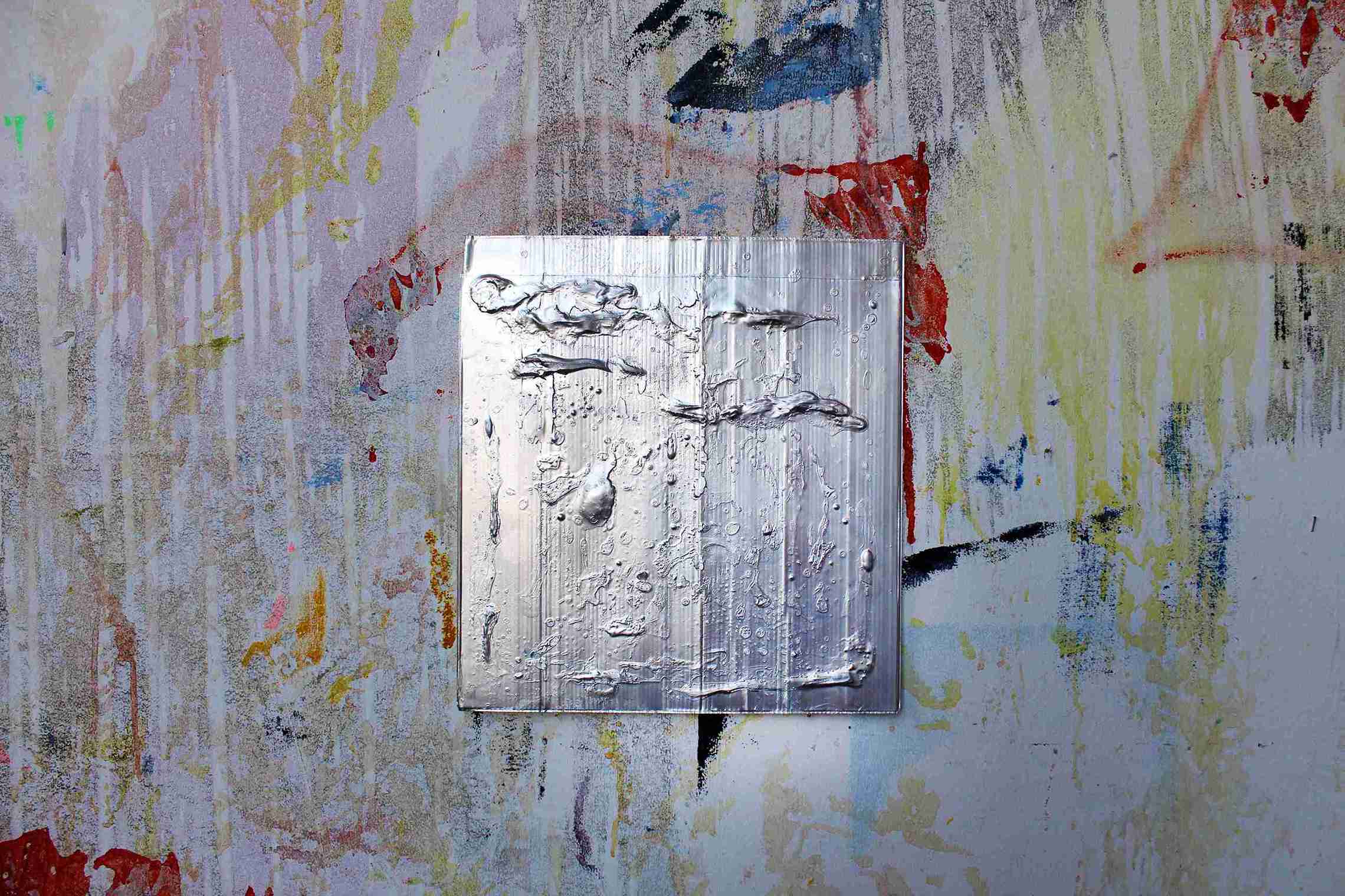 Metal looking painting on colourful painted wall.