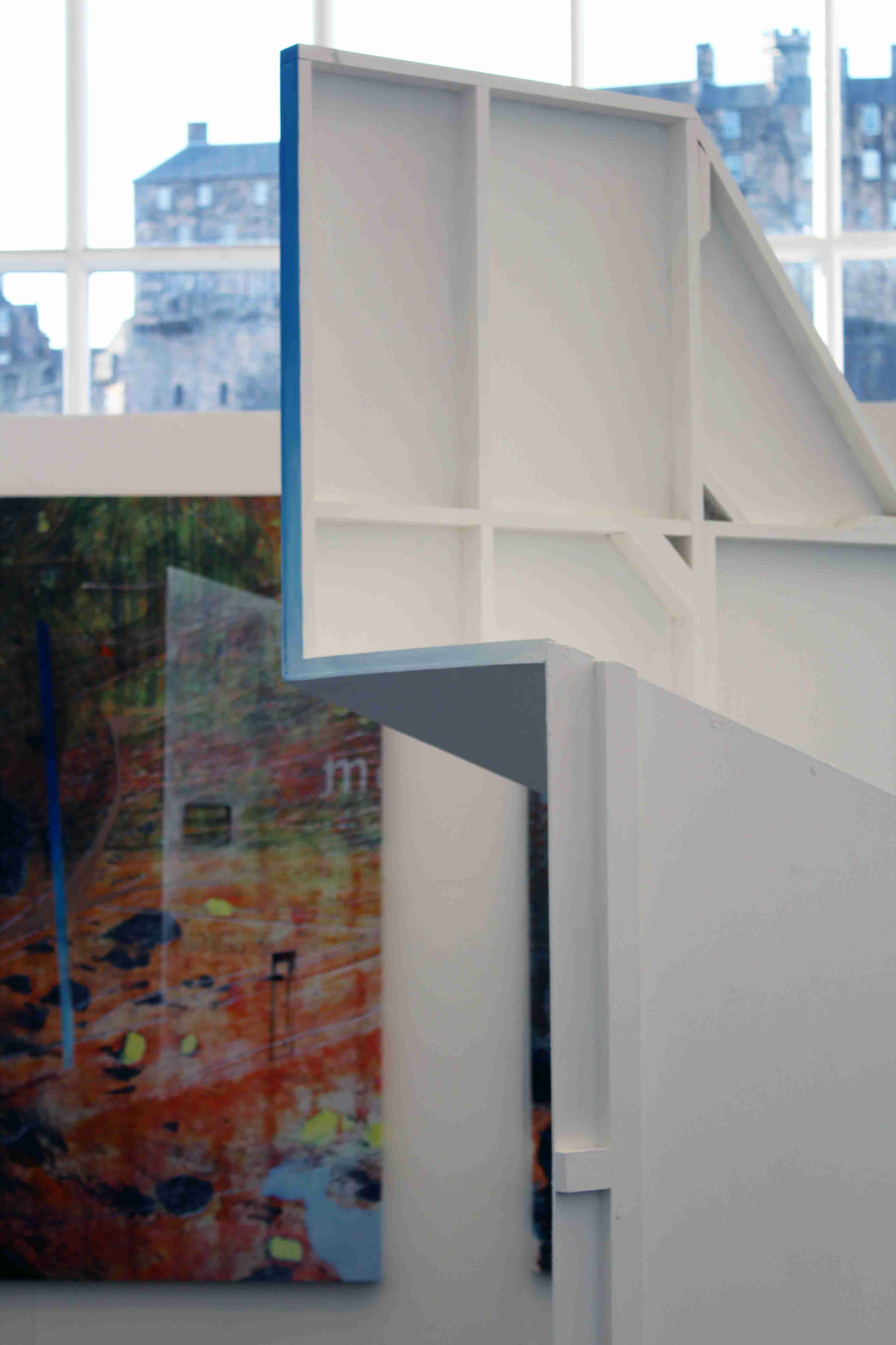 Large structural white wall with blue gradient painted strip in a gallery space