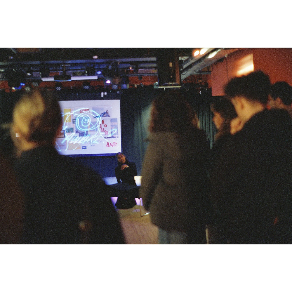 Audience members watching a live performance during an exhibition in a bar venue