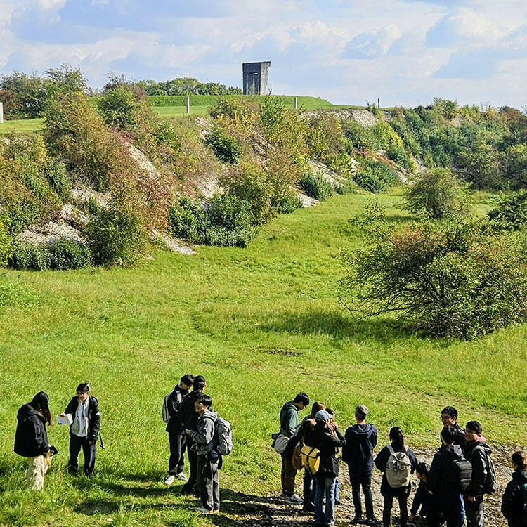 A view across the Bonarka Geological Reserve, looking towards the Torn Hearts Monument, shows students investigating remnants of an ancient sea floor within the former limestone quarry.