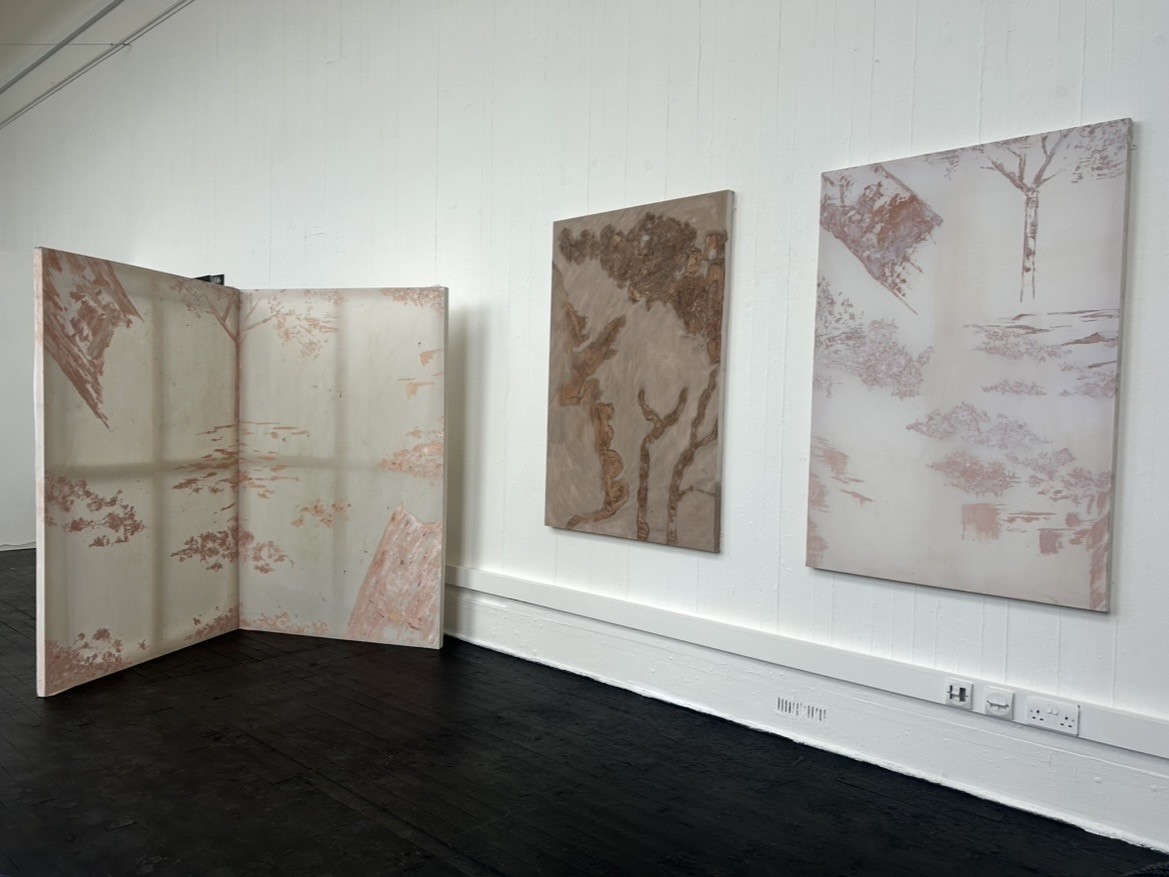 Three paintings displayed on wall.