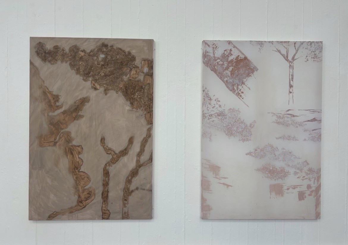 Two paintings displayed on wall.