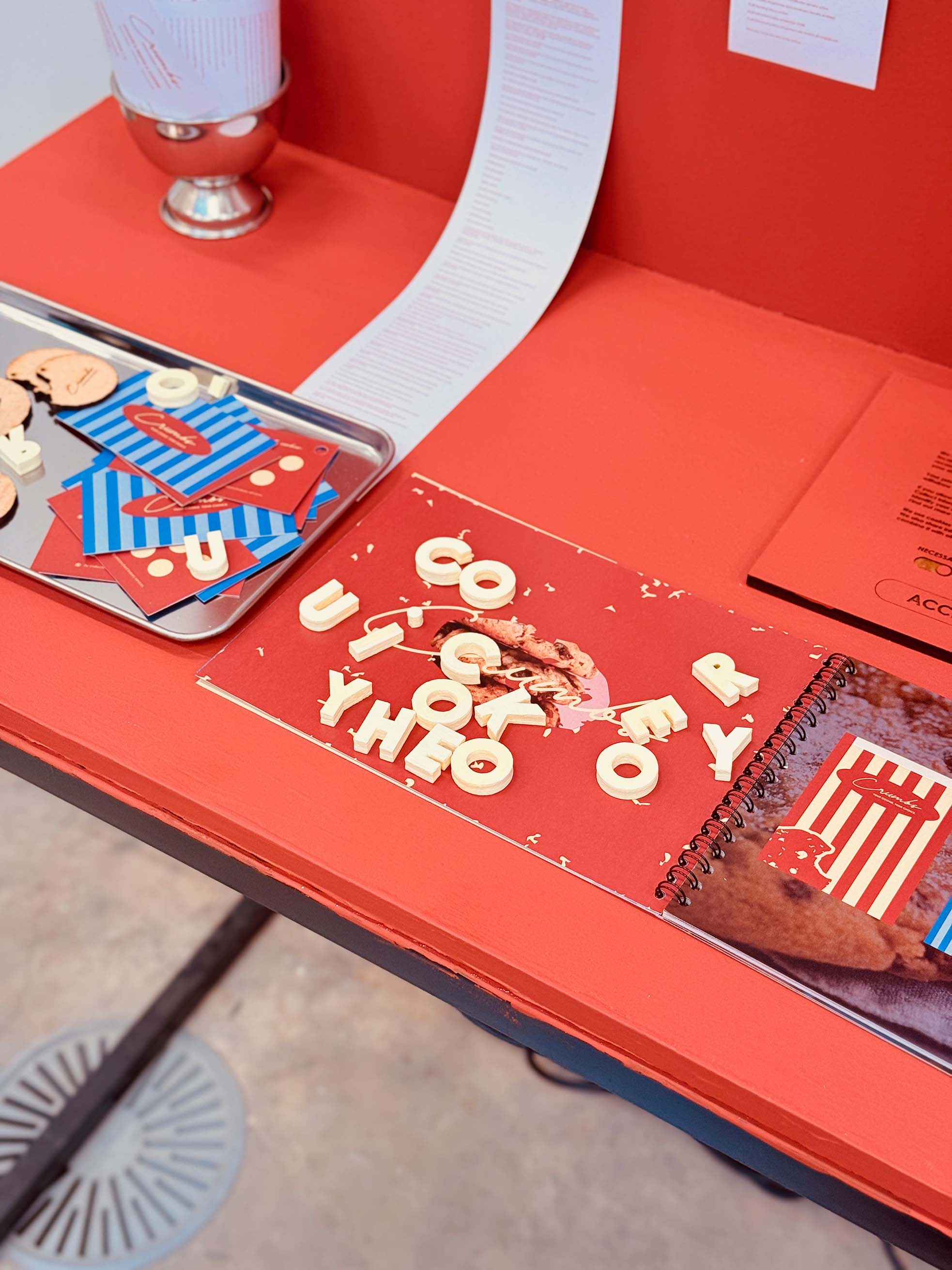 An open brand identity manual surrounded by various brand collateral items.