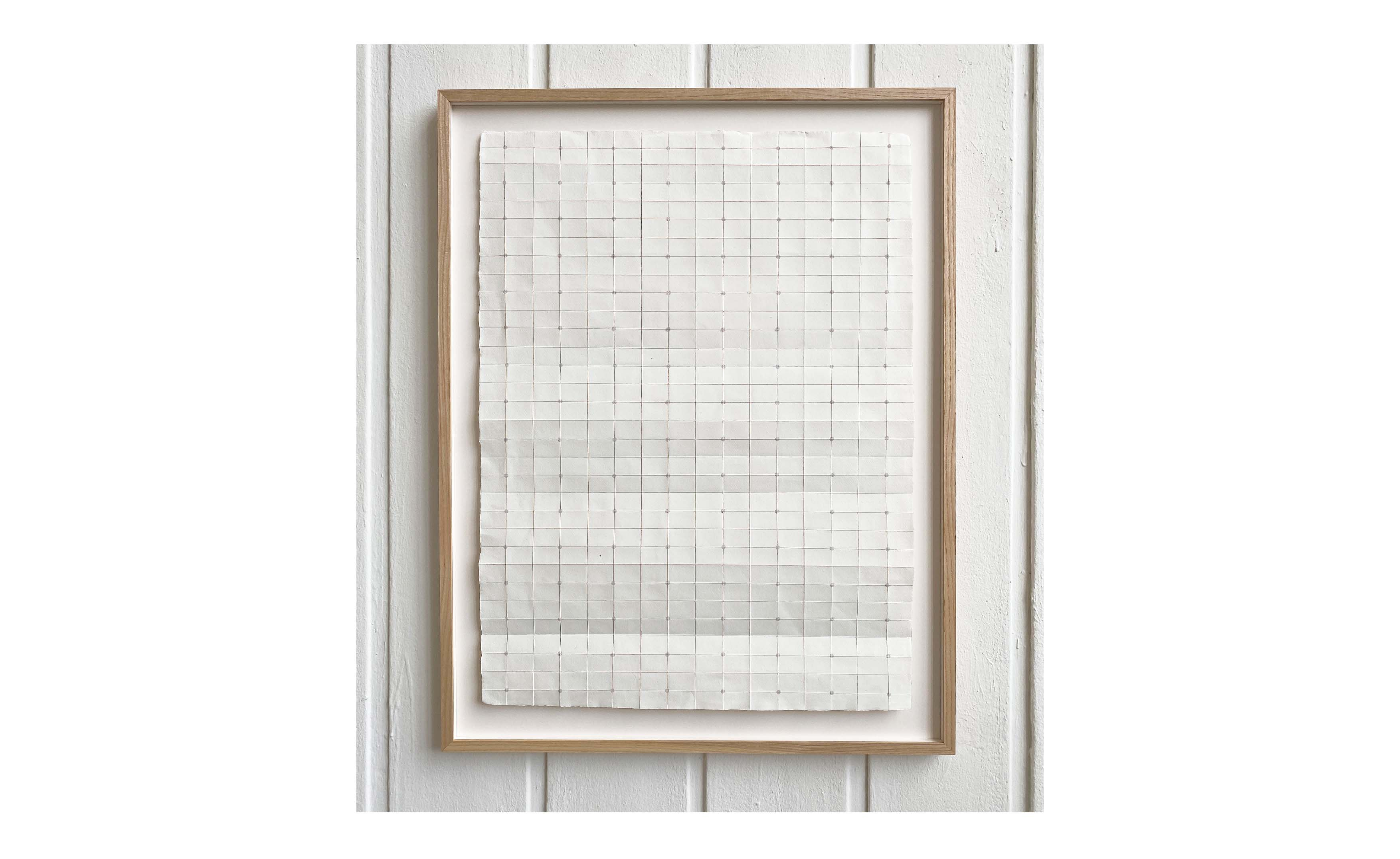 geometric drawing on paper in wooden frame displayed on a wall
