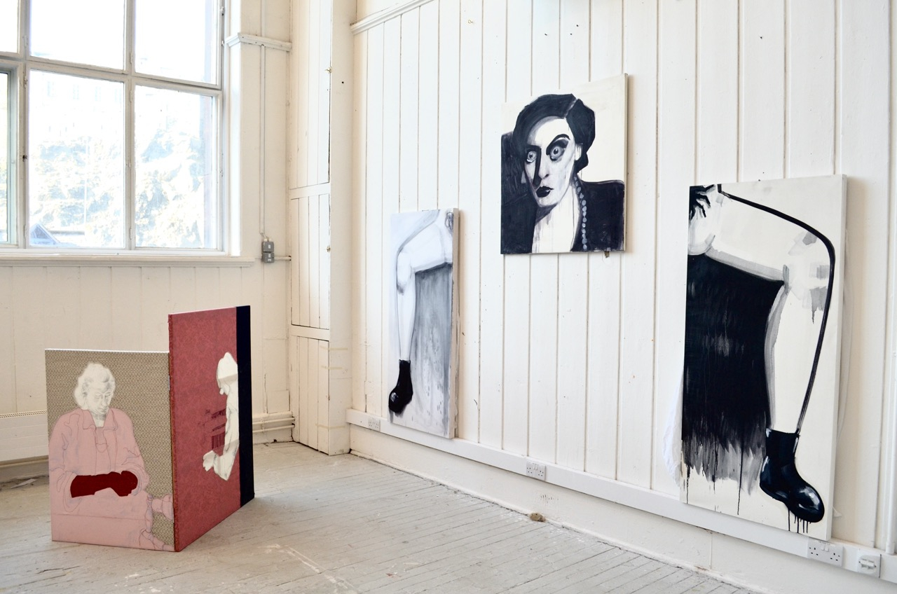 Joan Crawford with manspreading legs either side of her in black and white, with a textile screen to the left 