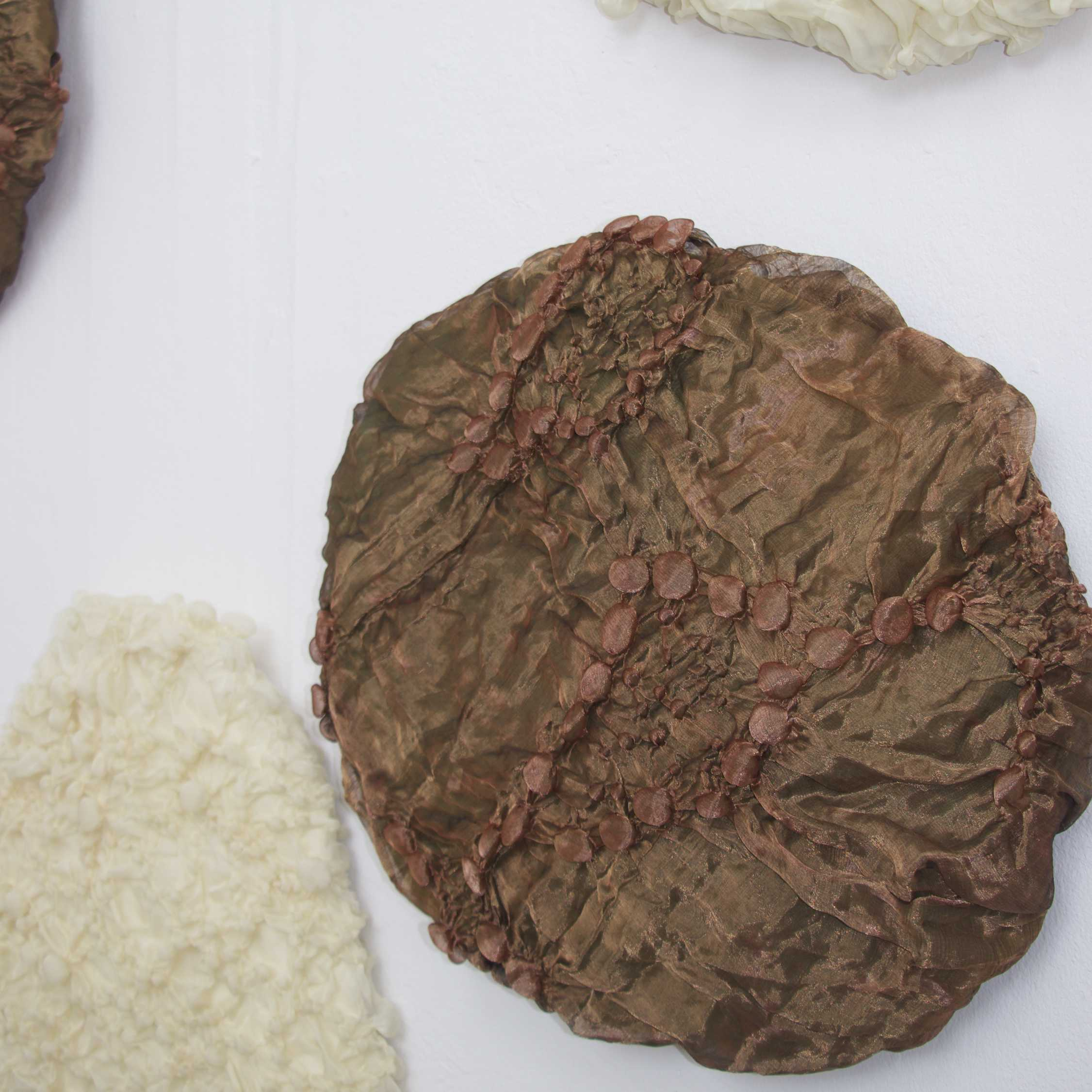 Detail showing the 3D pattern on a gold, rock shaped textile cushion