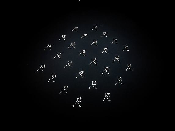 A grid of small glowing human figures projected onto a dark floor.
