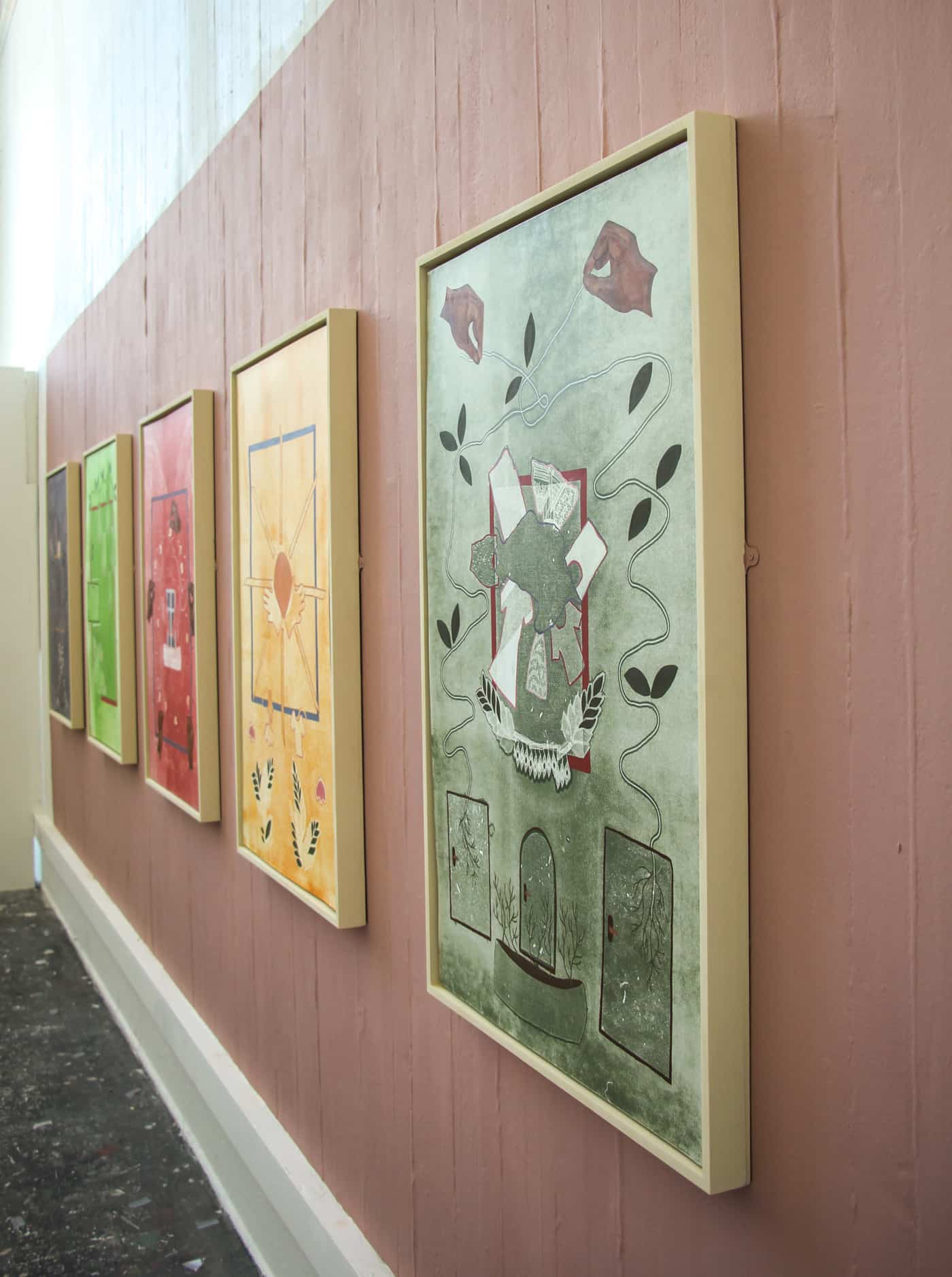 five mono-prints installed on a pink wall - side picture