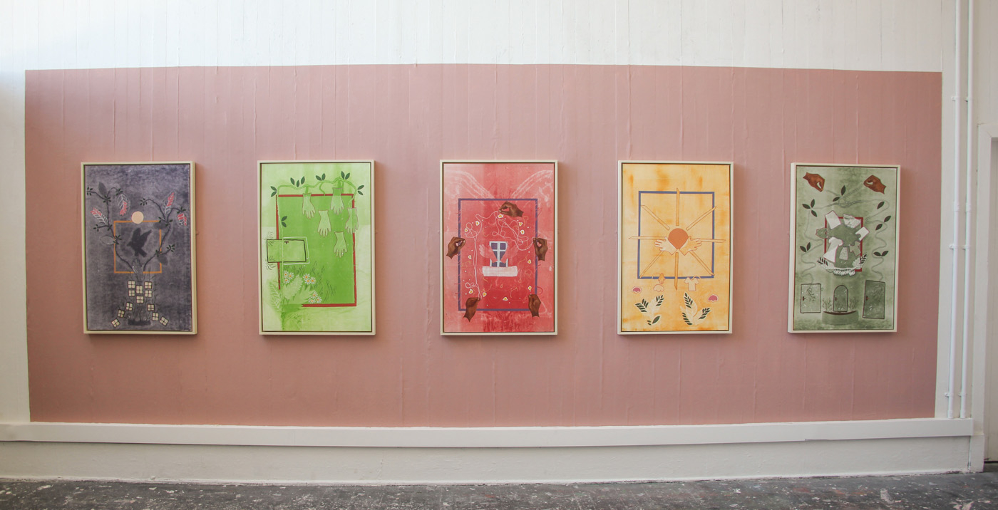 five mono-prints installed on a pink wall