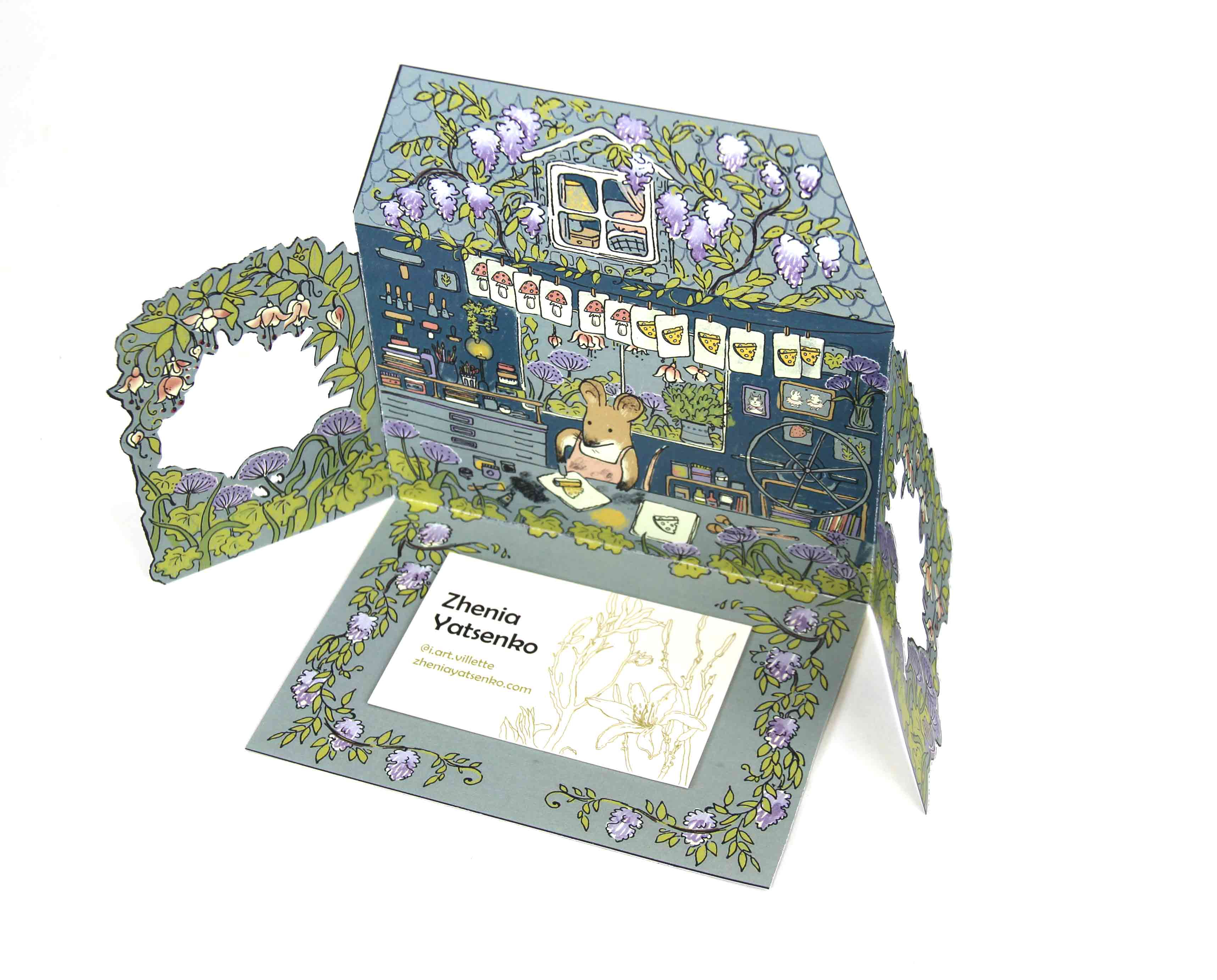 Colourful illustration of a mouse in her printmaking studio, with cutouts and folds.