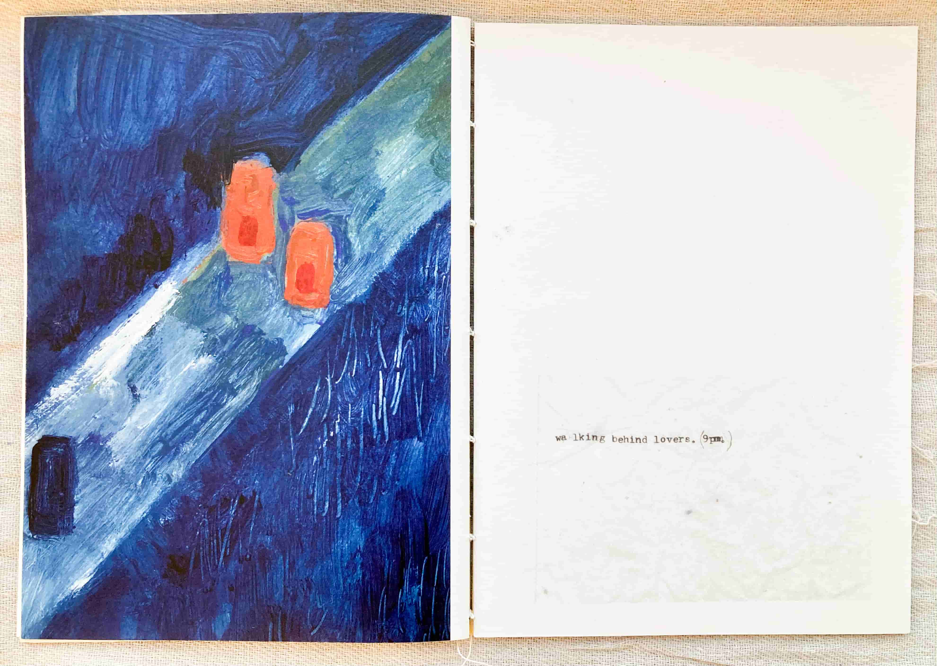 Open page of a book. Blue painting on one side, on the other it reads "walking behind lovers, 9pm"