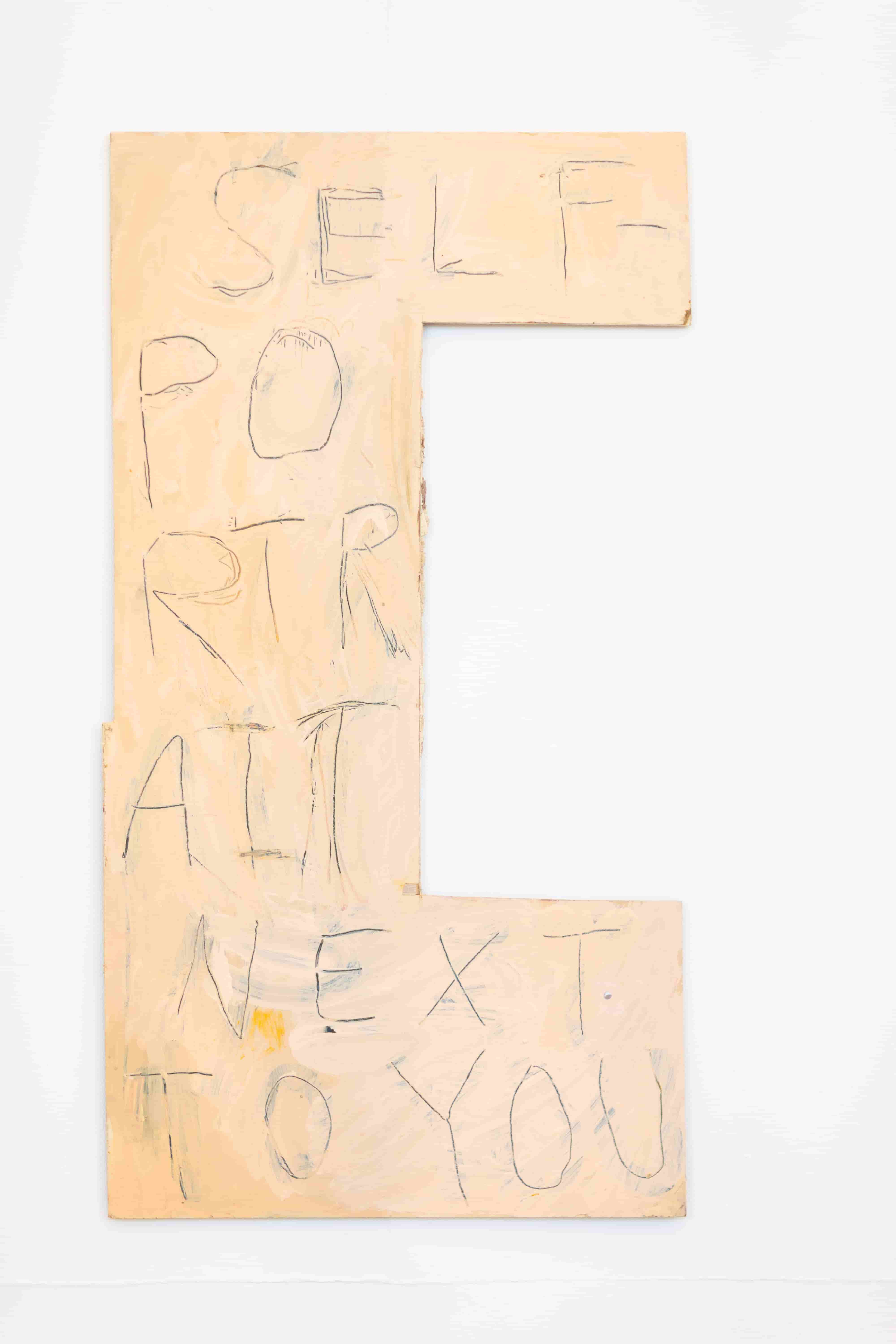 A large cream and blue painting with the writing 'Self-Portrait Next To You' in large letters across it