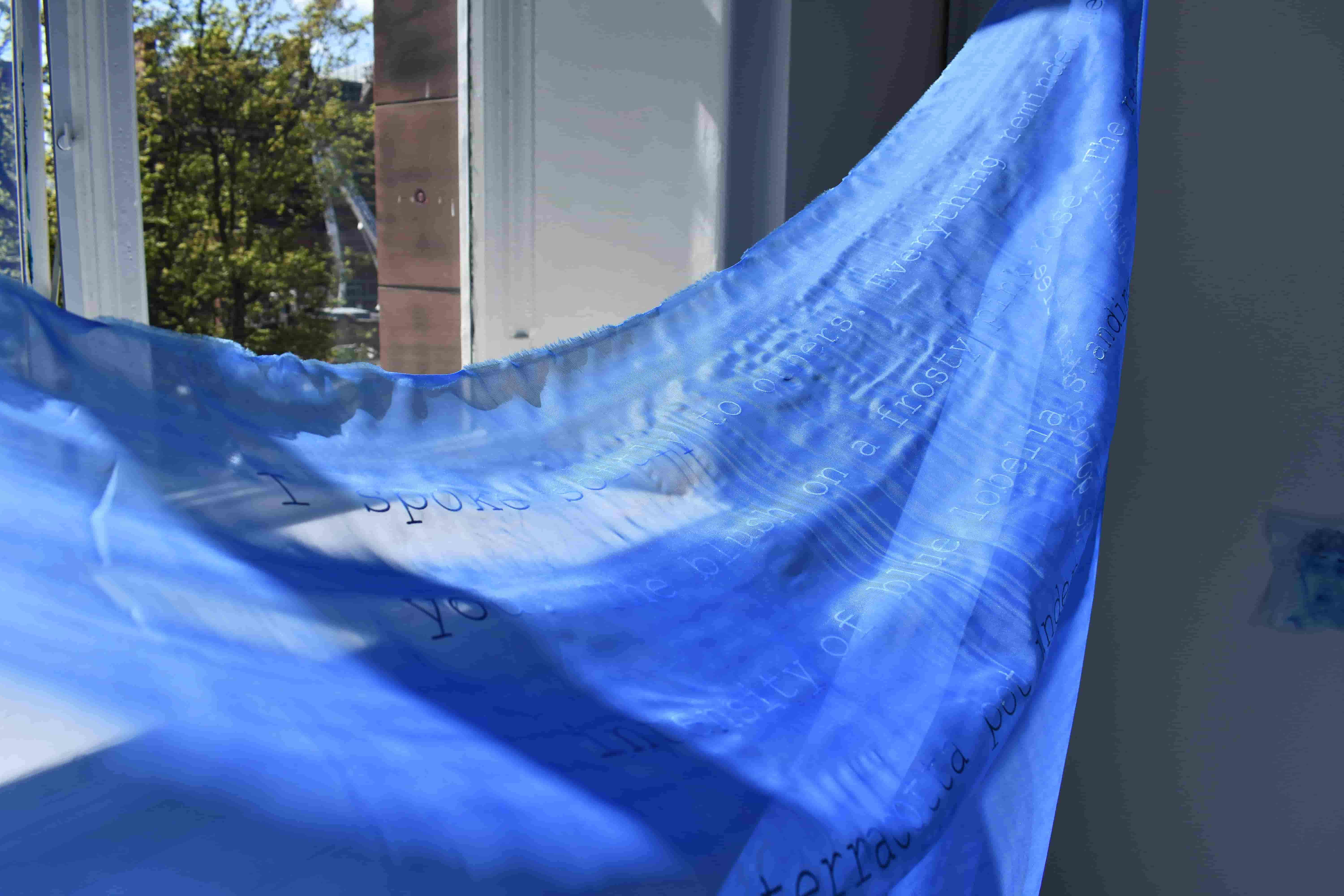 draped sheer blue fabric with printed text