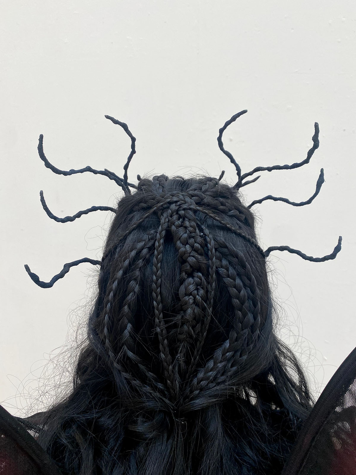 A close up shot of Manon Blackbeak's dragon headpiece and braided wig.