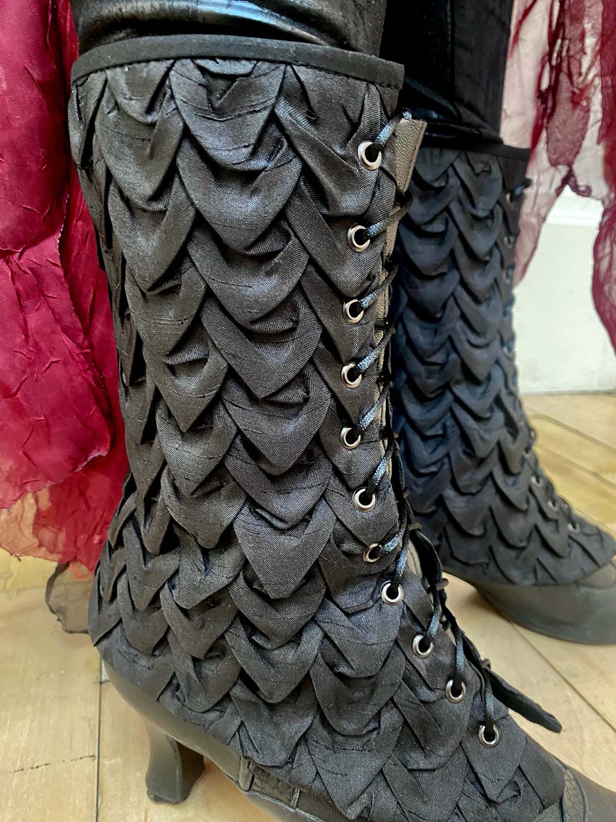 Close up shot of the costume's smocked dragon scale spats and boots.