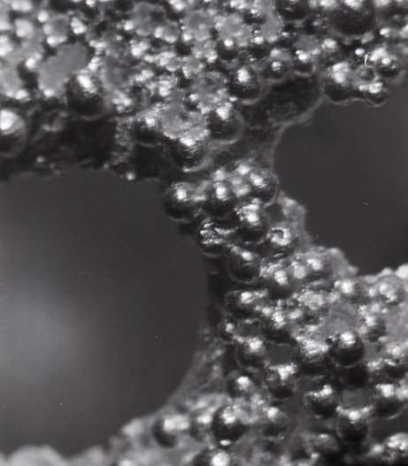 A close up of the granulation texture which consists if small spheres on the surface of the metal.