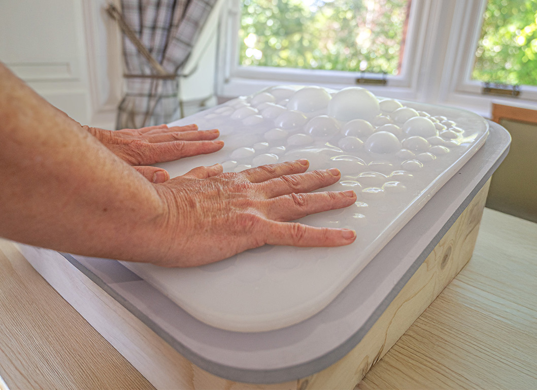 Carer interacting with bubbles of the flo mattress 