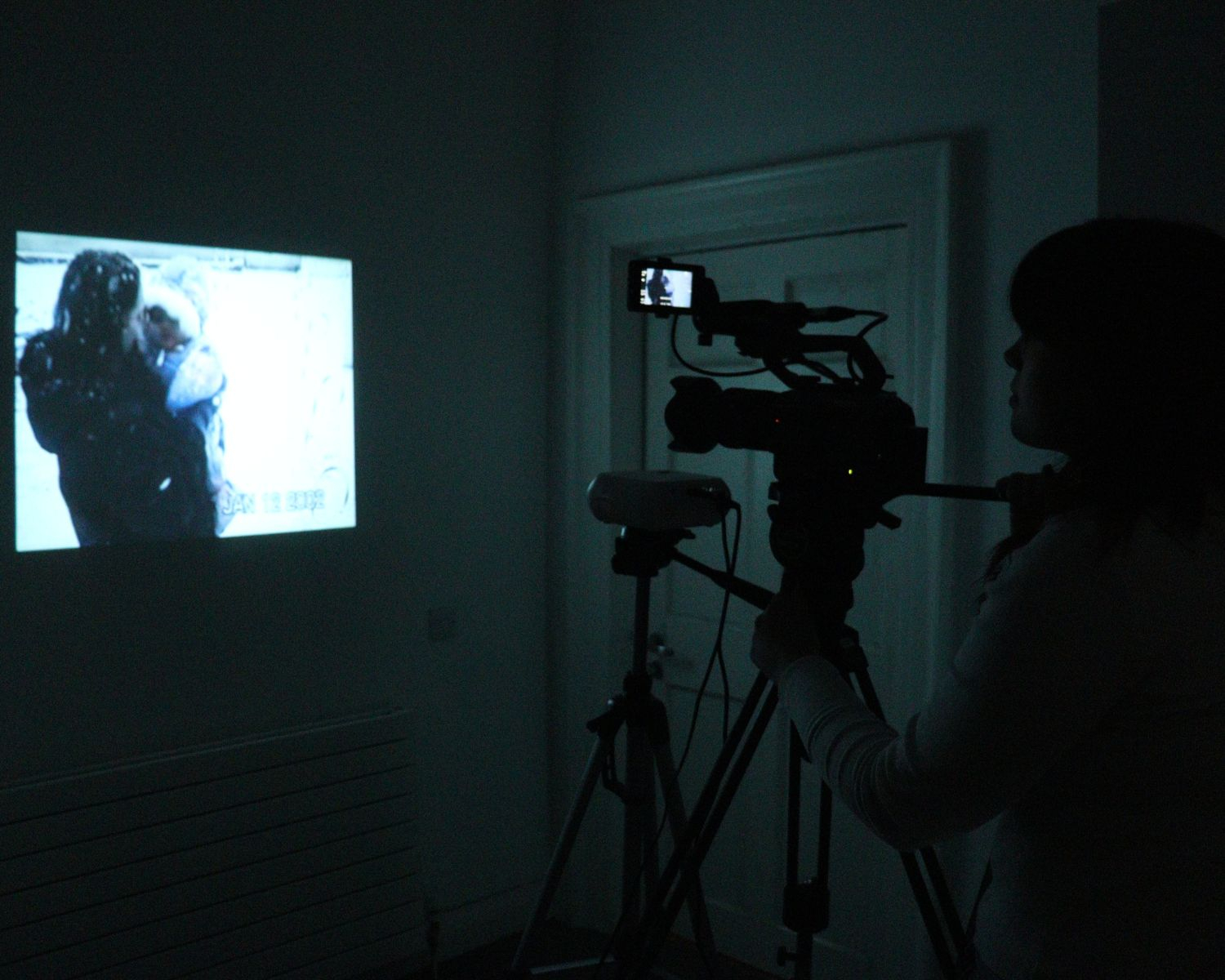 Me in the darkness filming archive videos projected onto my wall