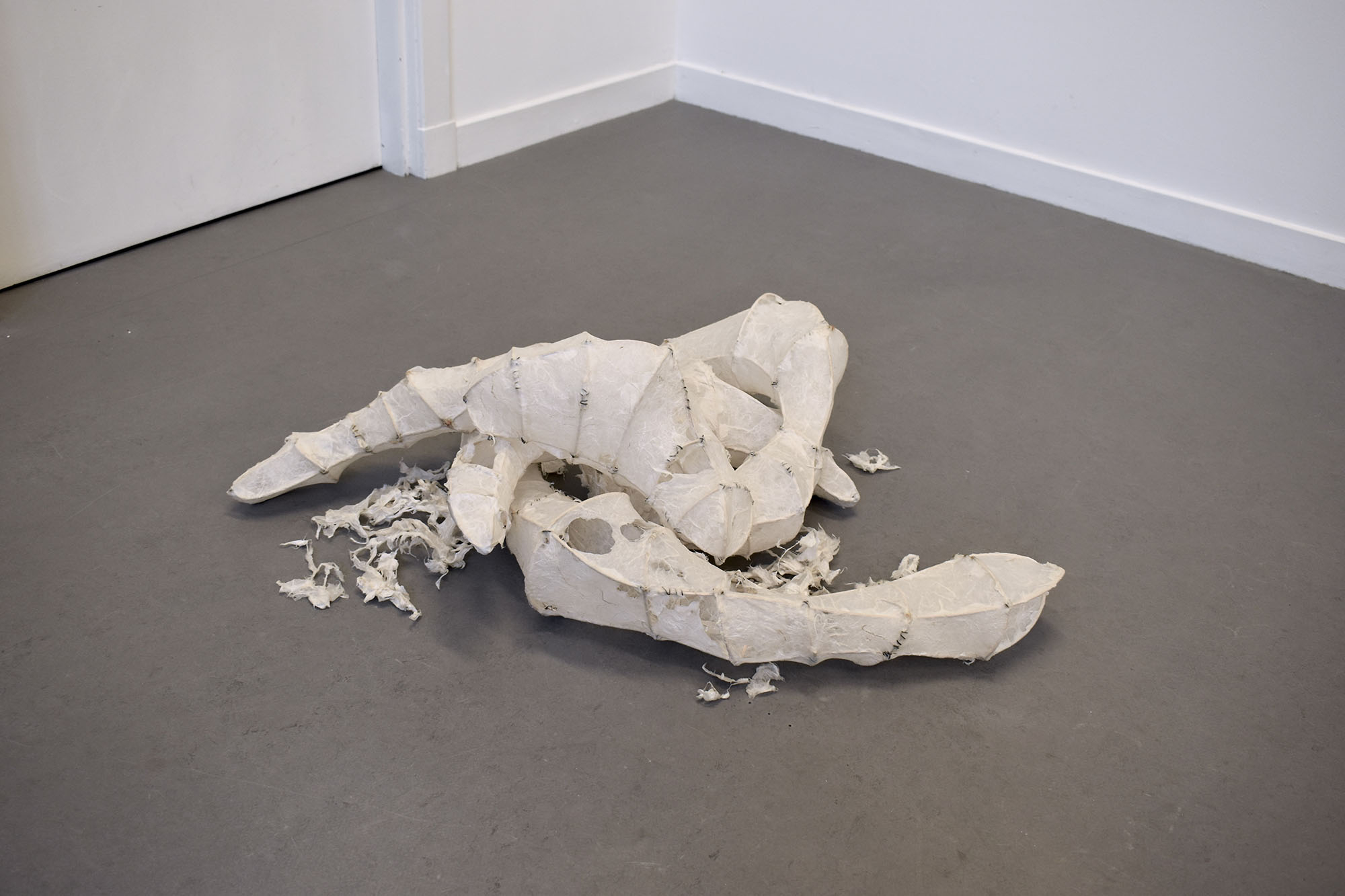 A pile of rice paper sculptures. Some are torn to look as though decaying.