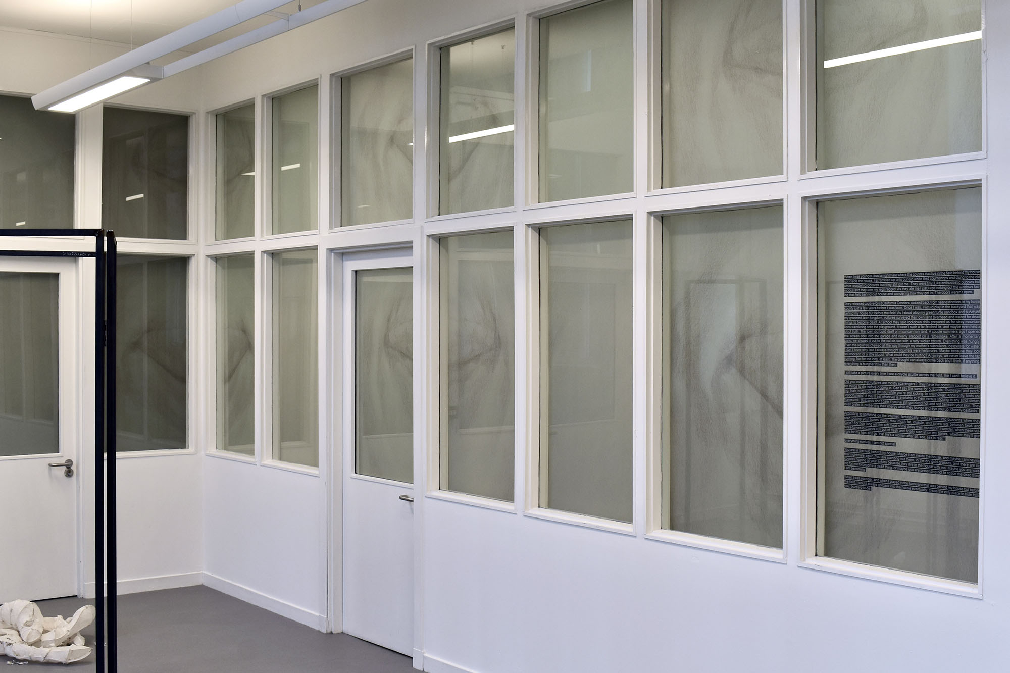 A series of tracing paper prints covering windows from the inside. Upon the prints are a set of mirrored and repeating closed eyes.