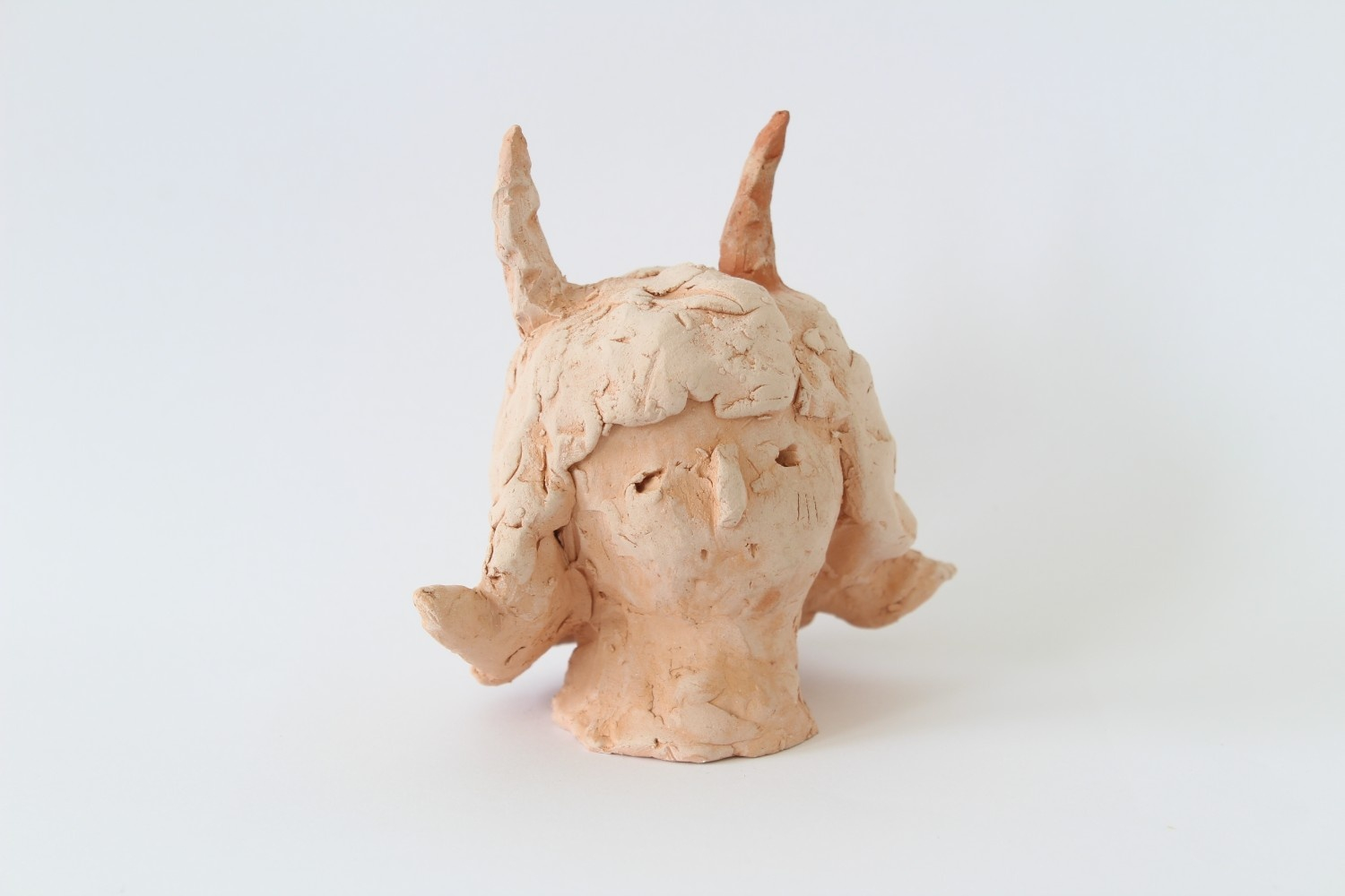Ceramic terracotta sculpture of a woman's head with devil ears