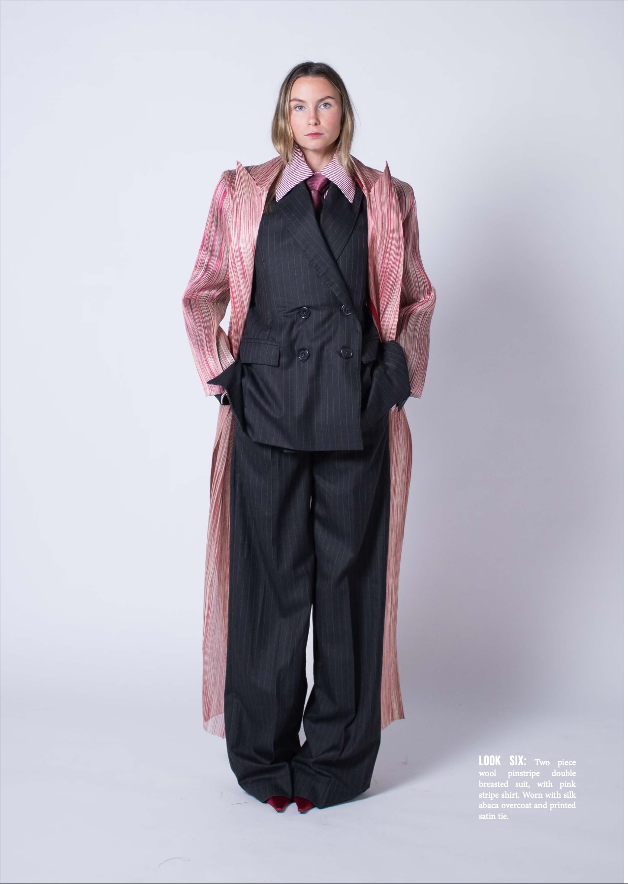 Model wears pinstripe suit with a striped shirt, tie and striped silk abaca overcoat