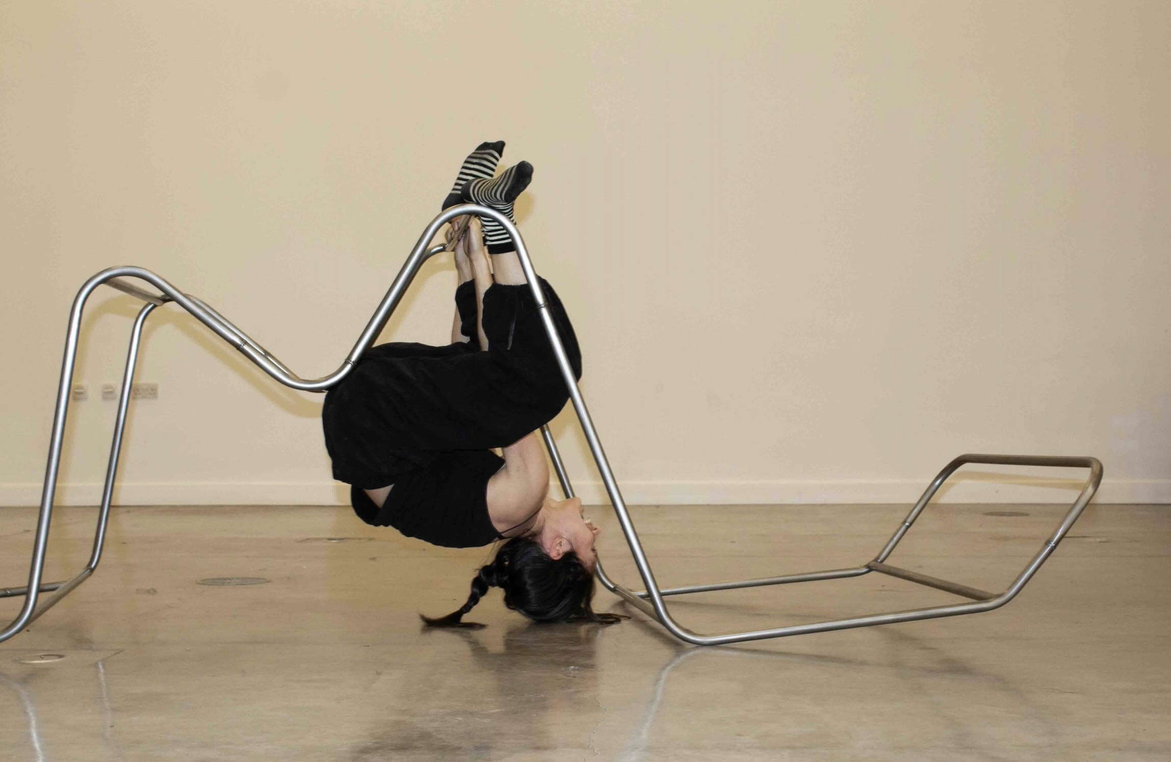 Pictured: figure hanging upside down from the 'm frame'