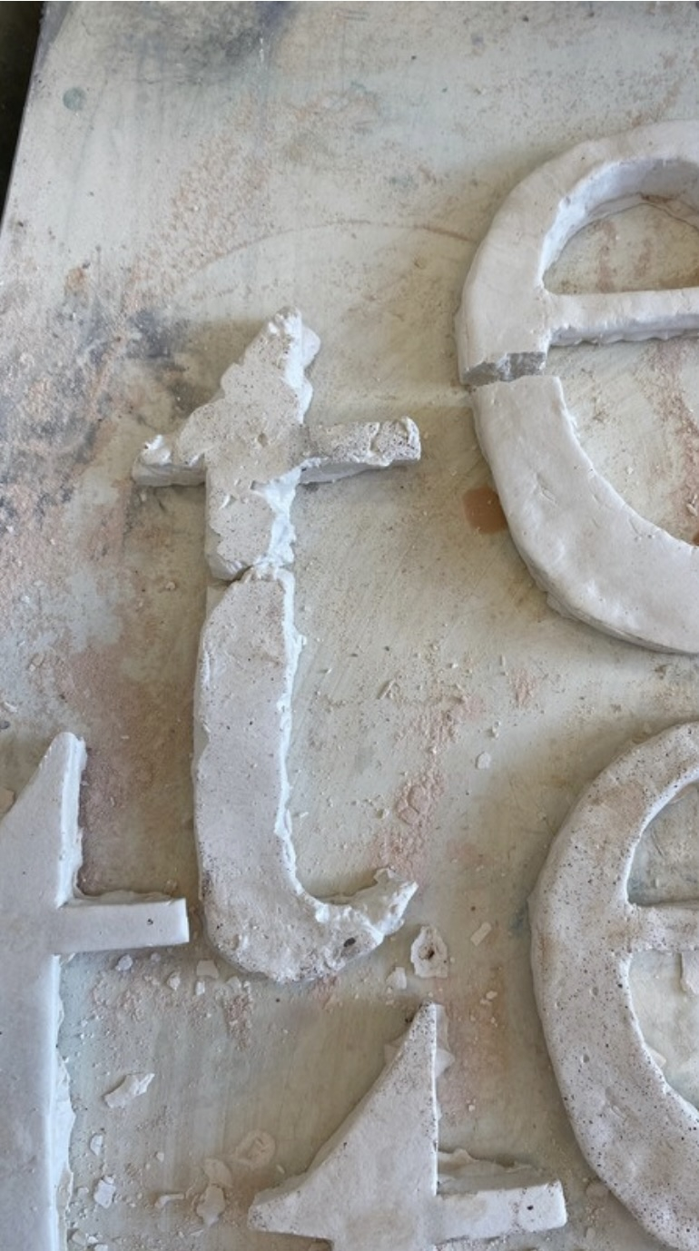 Pictured: details of cast plaster letter forms 't' and 'e'