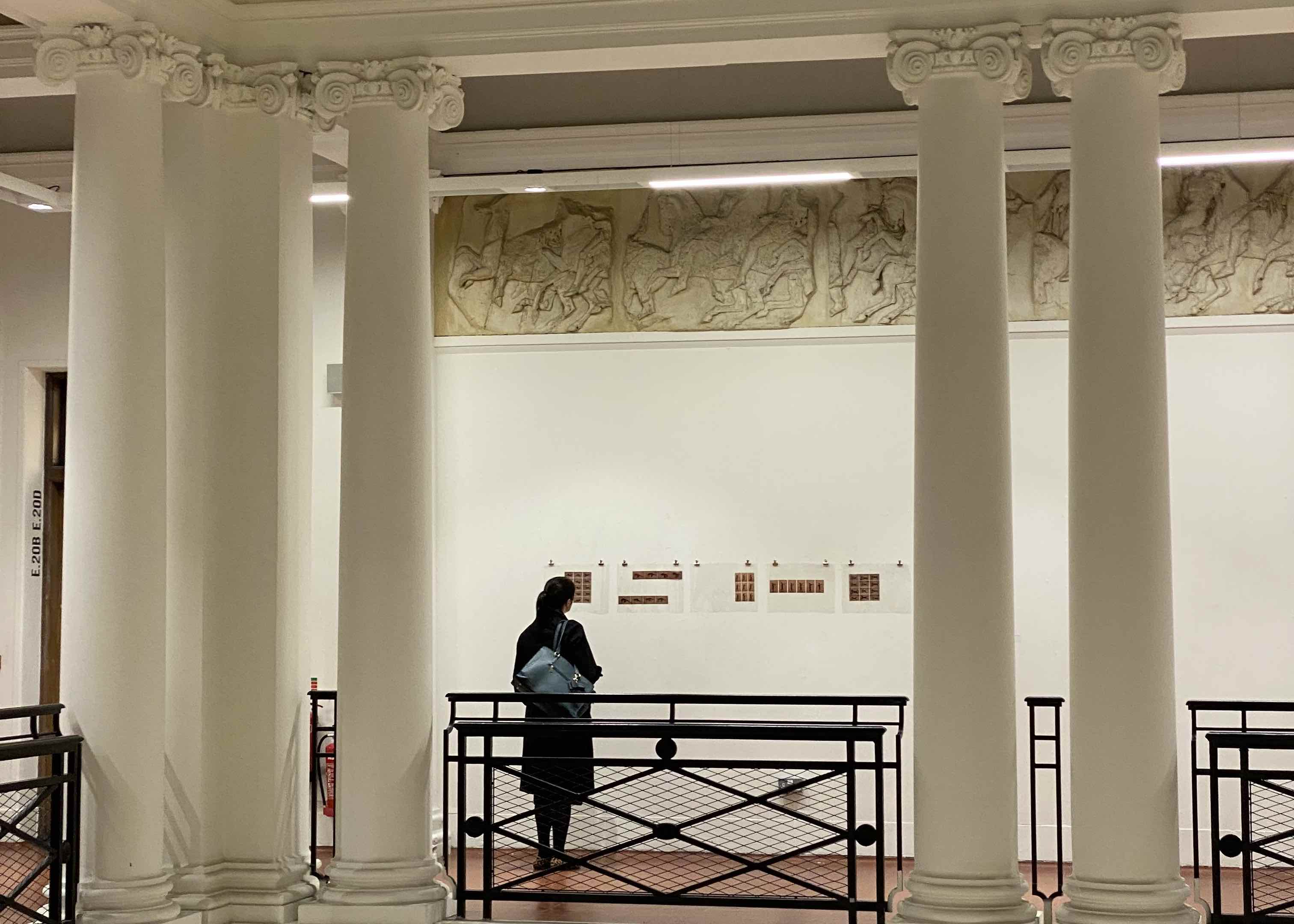 Digital photographs on acetate pictured displayed between pillars in the ECA sculpture court.