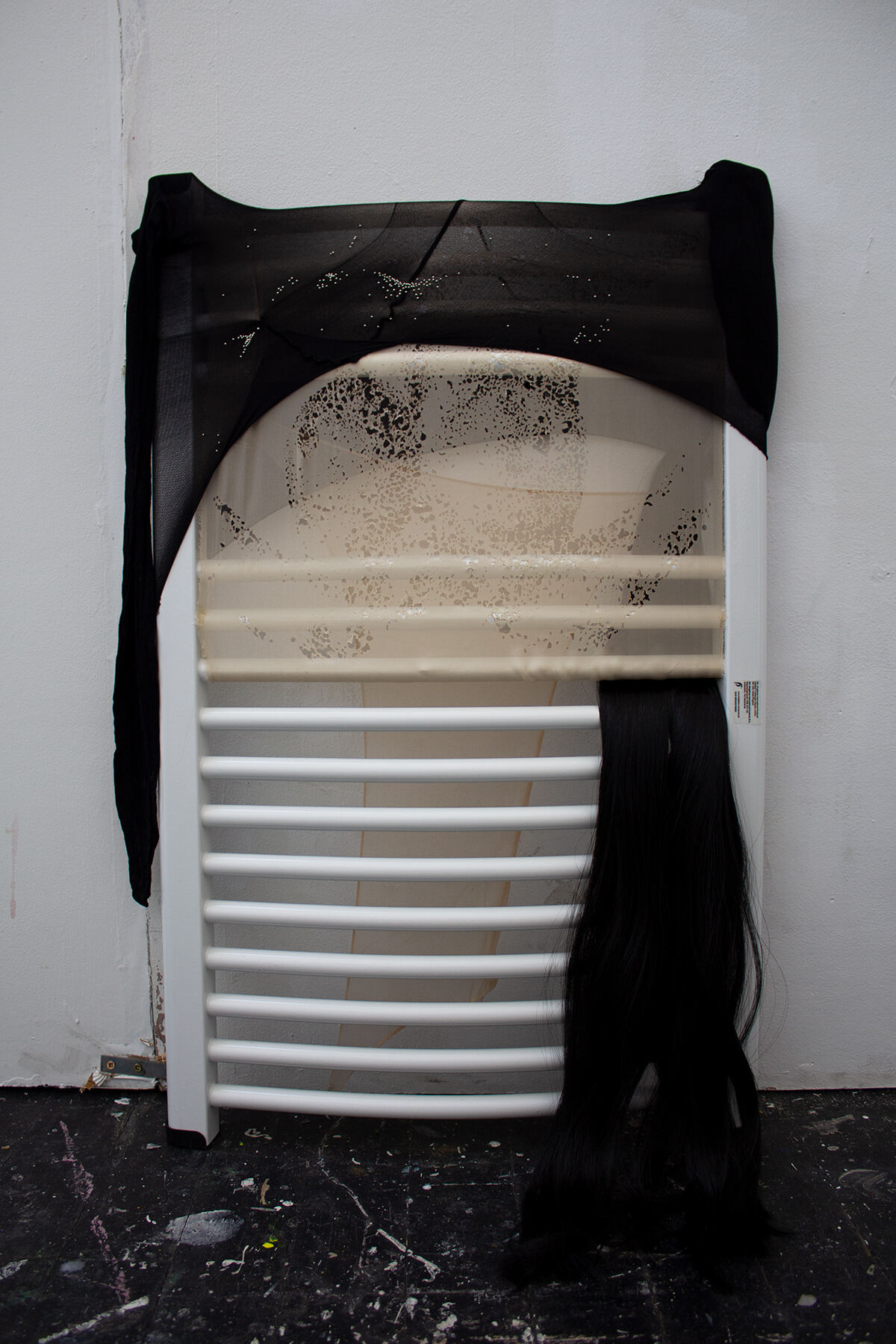 Tight with the Heating, 2026 Sculpture, Chiffon, Pins, Nylon Tights, Glue, Hair, Radiator, 40 x 80 cm
