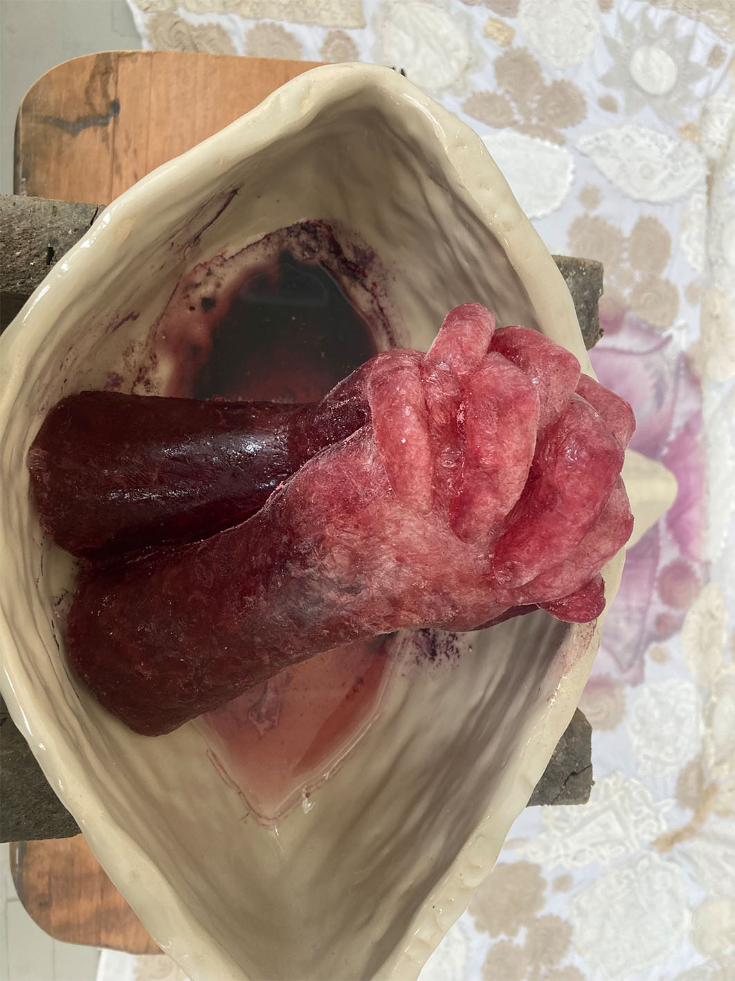 Image of sculture of two hands clasping, made from frozen wine.
