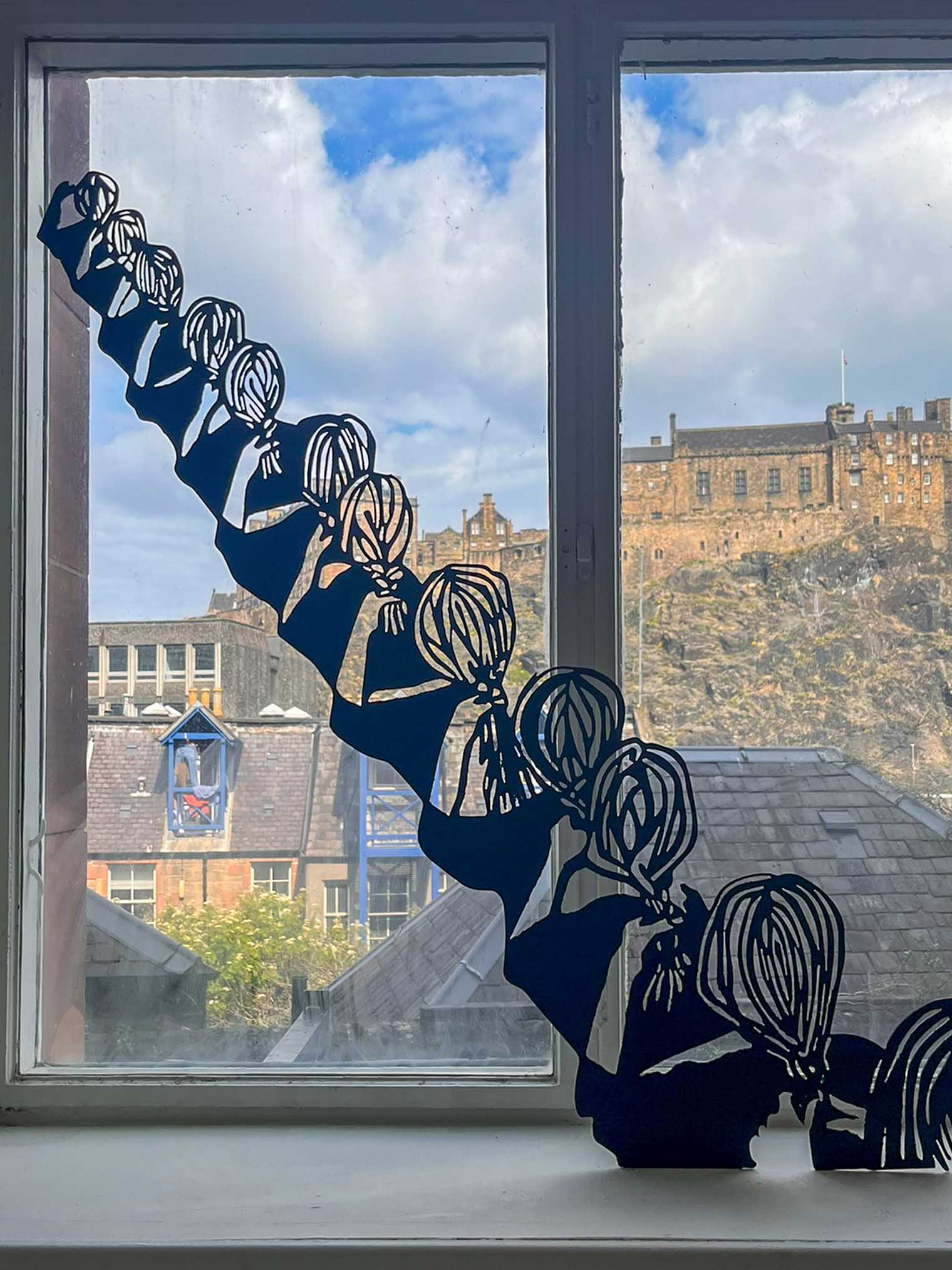 Abstract plasma-cut black figure placed by a window.