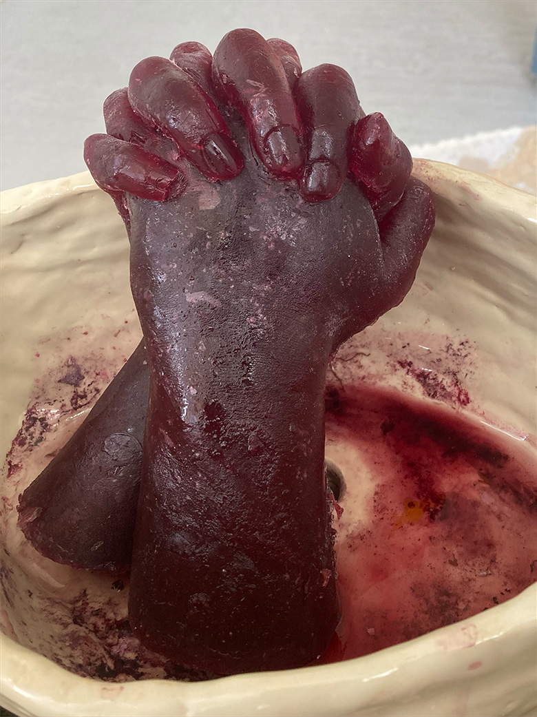 Image of sculpture of two hands clasping, made from frozen wine.