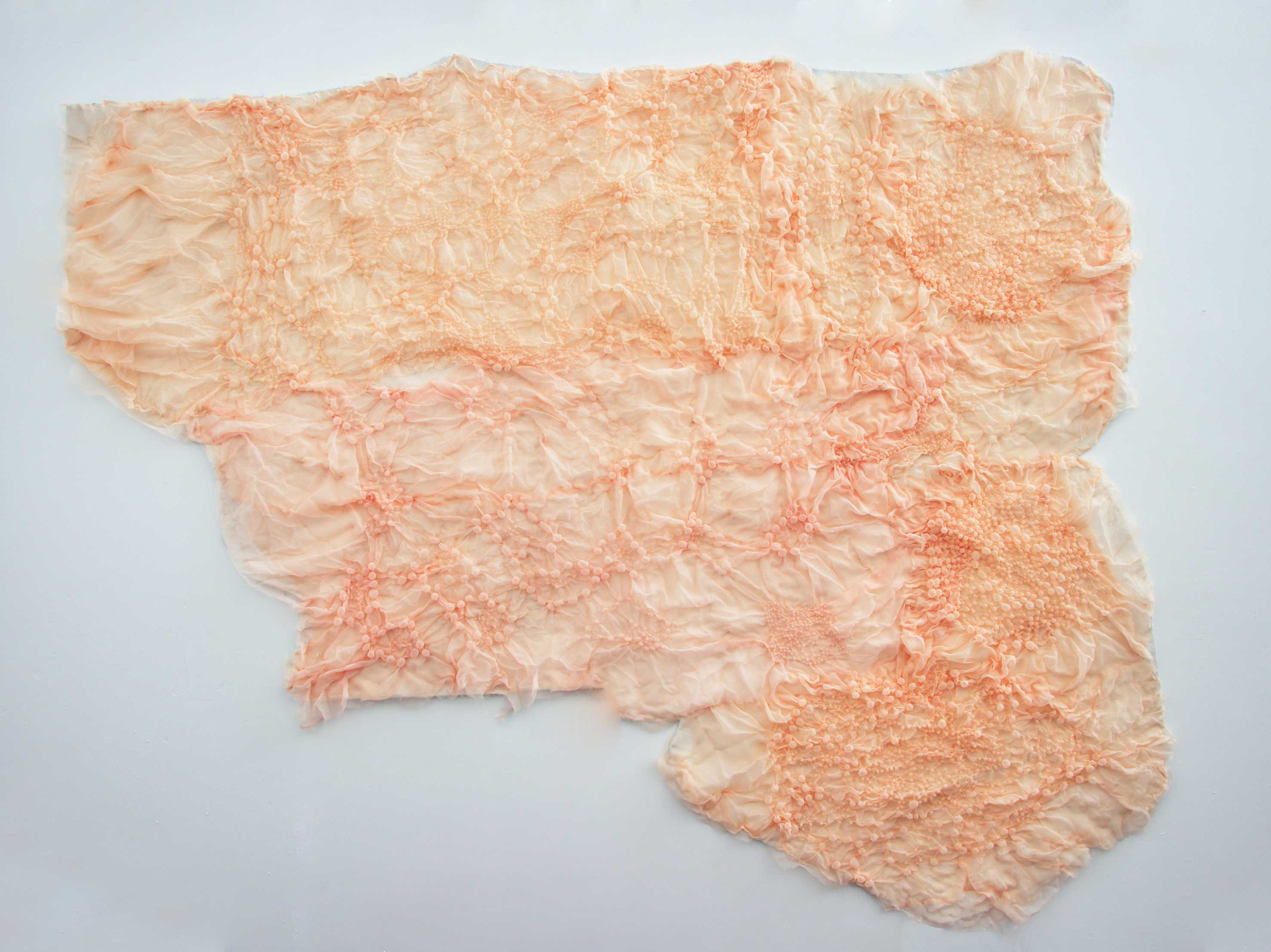 Nuances of pink, bubbly polyester fabric mounted on the wall, in an abstract shape