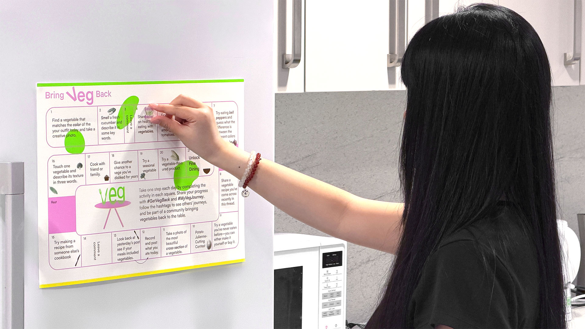 A participant engaging with the Bring Veg Back interactive campaign board in a kitchen setting.