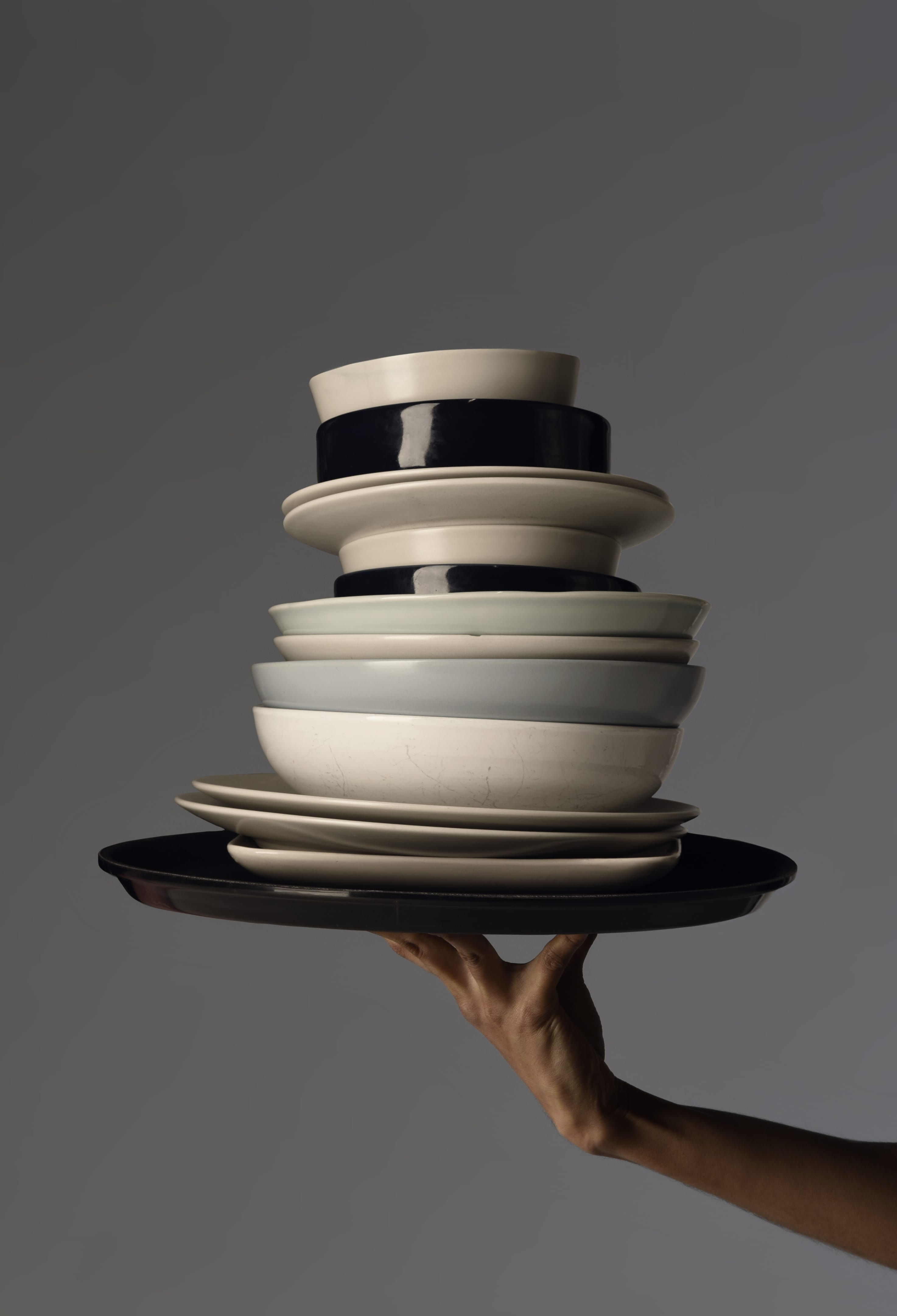 Image of stack of plates in a tray held by a single hand