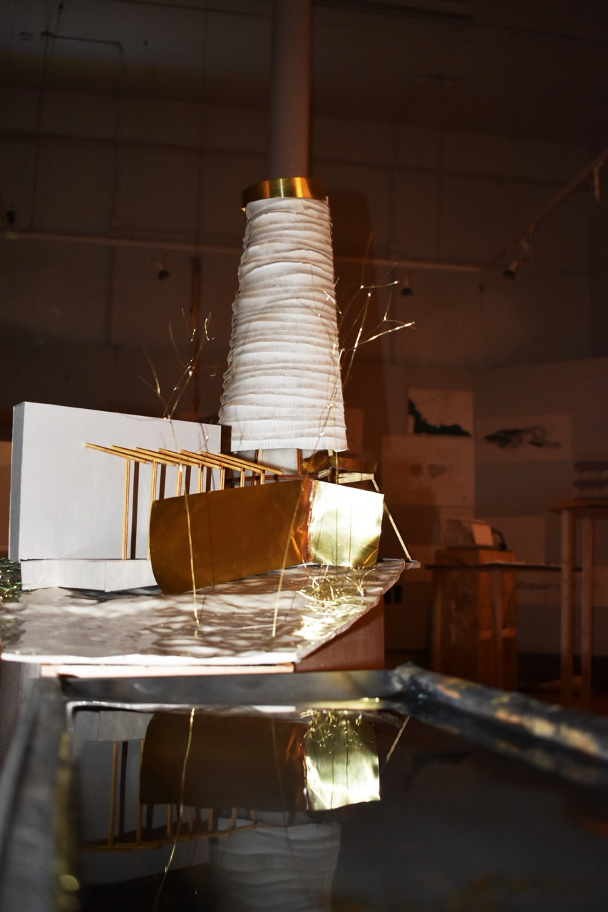 Photo of architectural model, depicting thatched chimney building surrounding by wire crafted trees.
