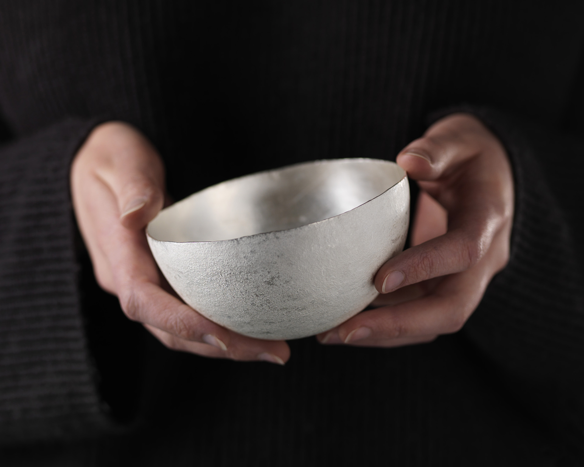 Image showing a silver bowl being held in a person's hands. The work is by Louisa Thomson, BA (Hons) Jewellery and Silversmithing